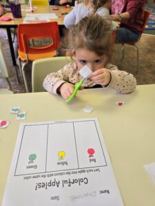 Child learning to use scissors